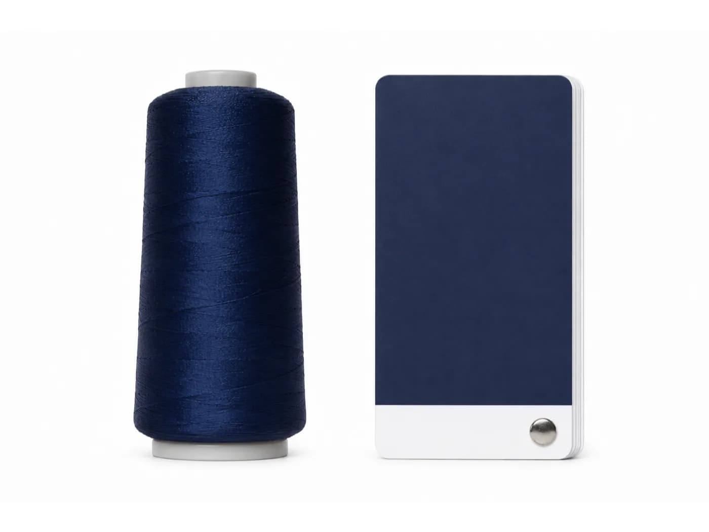 Bobine de fil de broderie marine posée à côté de la pastille Pantone la plus proche